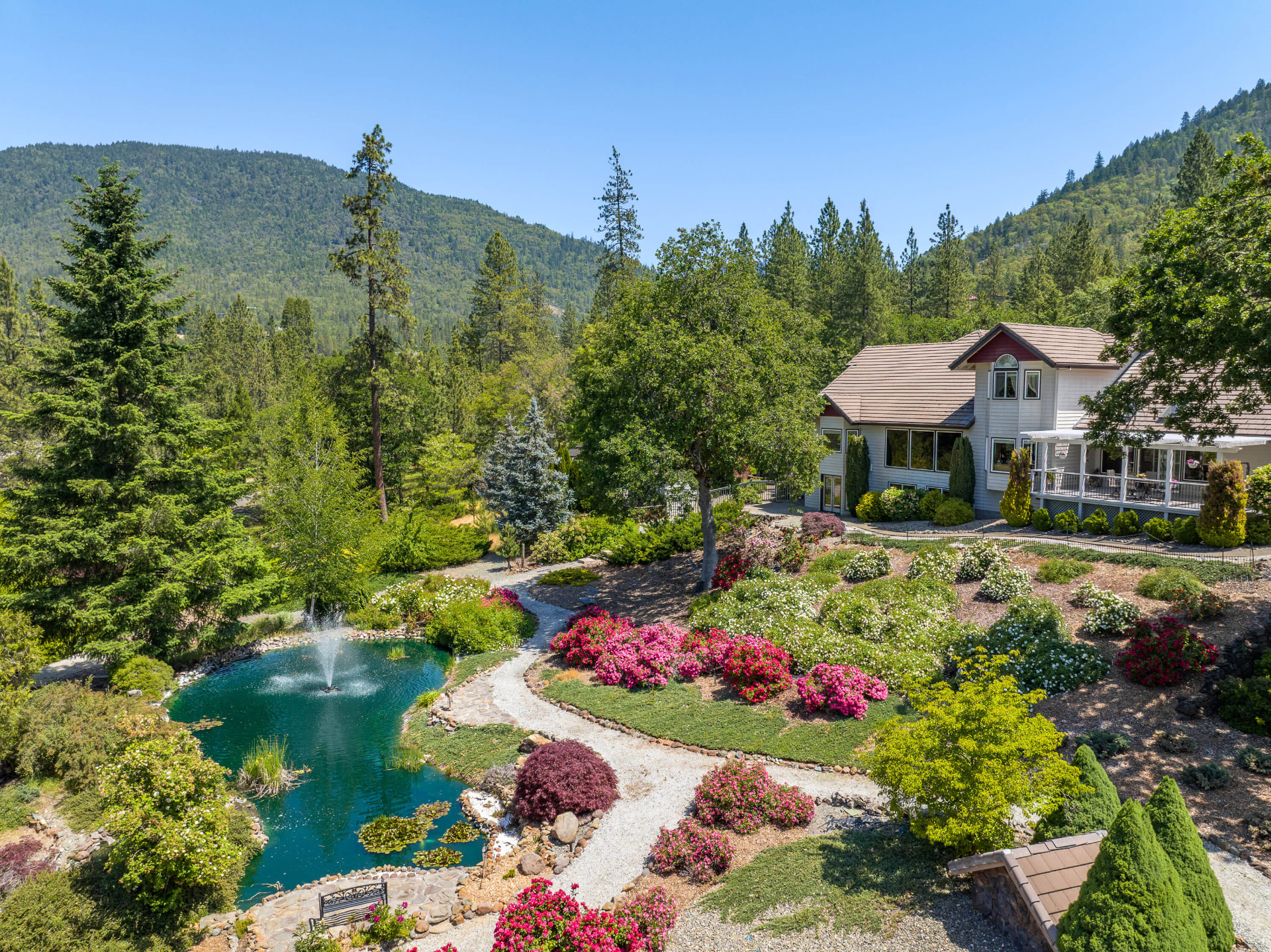 Aerial view of the fountain pond and water gardens, with the house at upper right and mountains beyond